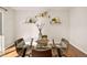 Dining room with hardwood floors, modern glass table with seating for four, and stylish floating wall shelves at 1827 Quail St # 8, Lakewood, CO 80215