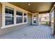 Covered back porch with wood flooring and a glimpse of the yard, creating an ideal space for relaxation and outdoor enjoyment at 13440 Monaco St, Thornton, CO 80602