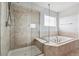 Bathroom showcasing a glass shower, soaking tub, and modern fixtures for a relaxing experience at 13440 Monaco St, Thornton, CO 80602