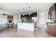 Modern kitchen with stainless steel appliances, a center island, and dark wood cabinets at 13440 Monaco St, Thornton, CO 80602