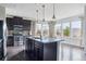 Bright, open kitchen with stainless steel appliances, granite countertops, and dark wood floors at 13440 Monaco St, Thornton, CO 80602