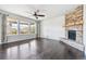 Bright living room featuring a stone fireplace, dark wood floors, and lots of natural light at 13440 Monaco St, Thornton, CO 80602