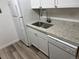 Well-lit kitchen with stainless steel sink, white appliances, and granite countertops at 910 S Walden St # 101, Aurora, CO 80017