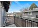 A balcony overlooks the neighbor homes and parking area with mature trees and blue sky at 1289 S Wheeling Way, Aurora, CO 80012