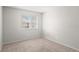 Carpeted bedroom featuring a bright window, neutral walls and baseboard trim at 1289 S Wheeling Way, Aurora, CO 80012