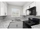 Updated kitchen featuring white cabinets, modern appliances, and a bright window with natural light at 1289 S Wheeling Way, Aurora, CO 80012