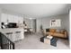 Open-concept living room with modern furniture, plush carpet, and a bar leading to the dining area at 1289 S Wheeling Way, Aurora, CO 80012