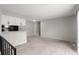 Open living space with kitchen view, featuring plush carpeting and a modern, neutral color palette throughout at 1289 S Wheeling Way, Aurora, CO 80012