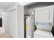 Utility closet with hot water heater and washing machine/dryer beside a closet with louvered doors at 1289 S Wheeling Way, Aurora, CO 80012