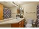 Modest bathroom with an integrated sink and vanity, basic fixtures, and a coordinated shower curtain at 17034 E Tennessee Dr # 105, Aurora, CO 80017