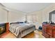 View of the bedroom featuring a fireplace, laminate floors, a window, and an antique dresser at 17034 E Tennessee Dr # 105, Aurora, CO 80017