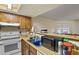 Traditional kitchen with wood cabinets, white appliances, laminate countertops, and a stainless-steel sink at 17034 E Tennessee Dr # 105, Aurora, CO 80017