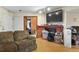 Interior view of the living room featuring a decorative fireplace, laminate floors, and a mounted television at 17034 E Tennessee Dr # 105, Aurora, CO 80017