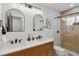 Modern bathroom featuring double sinks with white countertops, wood vanity, and glass-enclosed shower at 2814 N Harrison St, Denver, CO 80205