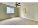 Spacious bedroom featuring neutral carpeting, modern ceiling fan, and natural light from the window at 4302 Nepal St, Denver, CO 80249
