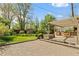 Expansive backyard featuring a covered patio, a built-in grill, and mature trees at 4425 Irving St, Denver, CO 80211
