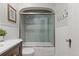 Bright bathroom with a tiled shower-over-tub, wood vanity and neutral decor at 4425 Irving St, Denver, CO 80211