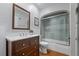 Bathroom featuring a vanity with storage and a shower over tub with glass doors and tiled walls at 4425 Irving St, Denver, CO 80211