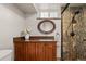Updated bathroom boasts a stylish vanity, decorative mirror, and tiled shower with glass enclosure at 4425 Irving St, Denver, CO 80211