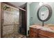 Stylish bathroom with a glass-enclosed shower, granite countertop, and decorative mirror at 4425 Irving St, Denver, CO 80211