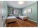 Charming bedroom showcasing hardwood floors, a window with blinds, and two twin beds with blue accents at 4425 Irving St, Denver, CO 80211