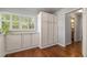 Hallway with hardwood floors and white cabinetry with natural light shining through window shutters at 4425 Irving St, Denver, CO 80211