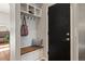 Convenient mud room with storage bench, coat hooks, and a sleek black door to compliment the space at 4425 Irving St, Denver, CO 80211