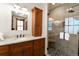 Bathroom featuring a walk-in shower, wood cabinets, granite counters, framed mirror, and tiled floors at 302 N Main St, Breckenridge, CO 80424