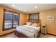 Bedroom featuring a wood frame bed, area rug, bedside table and large window at 302 N Main St, Breckenridge, CO 80424