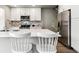 Bright kitchen featuring white cabinets, stainless steel appliances and an island with seating at 1927 S Peoria St, Aurora, CO 80014