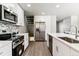 Modern kitchen features stainless steel appliances, quartz countertops, and stylish backsplash at 1927 S Peoria St, Aurora, CO 80014