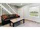 Comfortable living room featuring a stylish sofa and staircase access at 1927 S Peoria St, Aurora, CO 80014