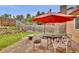 Charming backyard patio area with a table, chairs, an umbrella, and a landscaped garden at 13624 Omega Cir, Lone Tree, CO 80124
