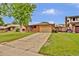 Charming single-story brick home with a well-maintained lawn and mature tree in a suburban neighborhood at 13624 Omega Cir, Lone Tree, CO 80124