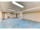 Unfinished basement features a blue carpet, offering ample storage or the potential for customization to suit your needs at 7118 W Elmhurst Ave, Littleton, CO 80128
