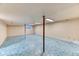 Unfinished basement with blue flooring, support beams, and fluorescent lighting at 7118 W Elmhurst Ave, Littleton, CO 80128