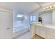 Well-lit bathroom boasts a jacuzzi tub and a separate vanity with ample counter space at 7118 W Elmhurst Ave, Littleton, CO 80128