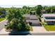 Two-story home showcases a neutral exterior, balcony, and two-car garage, surrounded by mature trees and a well-kept lawn at 7118 W Elmhurst Ave, Littleton, CO 80128