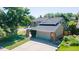 Two-story home boasts a neutral exterior, well-manicured lawn, large driveway, and attached two-car garage at 7118 W Elmhurst Ave, Littleton, CO 80128