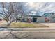 Charming home featuring a two-car garage and mature tree in the landscaped front yard at 7118 W Elmhurst Ave, Littleton, CO 80128