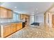 Modern kitchen boasting an island with granite countertops, wood cabinetry, and sleek appliances at 7118 W Elmhurst Ave, Littleton, CO 80128