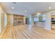 Inviting living room featuring hardwood floors, a stone fireplace, and an open kitchen concept at 7118 W Elmhurst Ave, Littleton, CO 80128