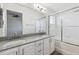 Bathroom featuring double sink vanity with granite counters and a tiled shower with sliding glass doors at 10174 Spotted Owl Ave, Highlands Ranch, CO 80129