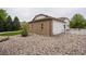 Exterior shot of home's brick and vinyl siding, next to a gravel, grass, and rock landscaped yard at 2151 Burbank St, Berthoud, CO 80513