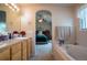 Bathroom featuring an arched entry to the primary bedroom and a large soaking tub at 2151 Burbank St, Berthoud, CO 80513