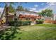 Expansive backyard featuring a pergola, lush green lawn, and mature trees at 7655 S Ogden Way, Centennial, CO 80122