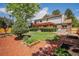 Landscaped backyard with a pergola-covered patio, lush lawn, and mature trees at 7655 S Ogden Way, Centennial, CO 80122