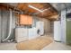 Basement laundry area with washer, dryer, storage cabinets, and water heater at 7655 S Ogden Way, Centennial, CO 80122