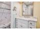 Updated bathroom featuring marble countertops, framed mirror, and tiled shower at 7655 S Ogden Way, Centennial, CO 80122