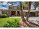 Attractive brick home with a covered front porch, lush landscaping, and a two-car garage at 7655 S Ogden Way, Centennial, CO 80122